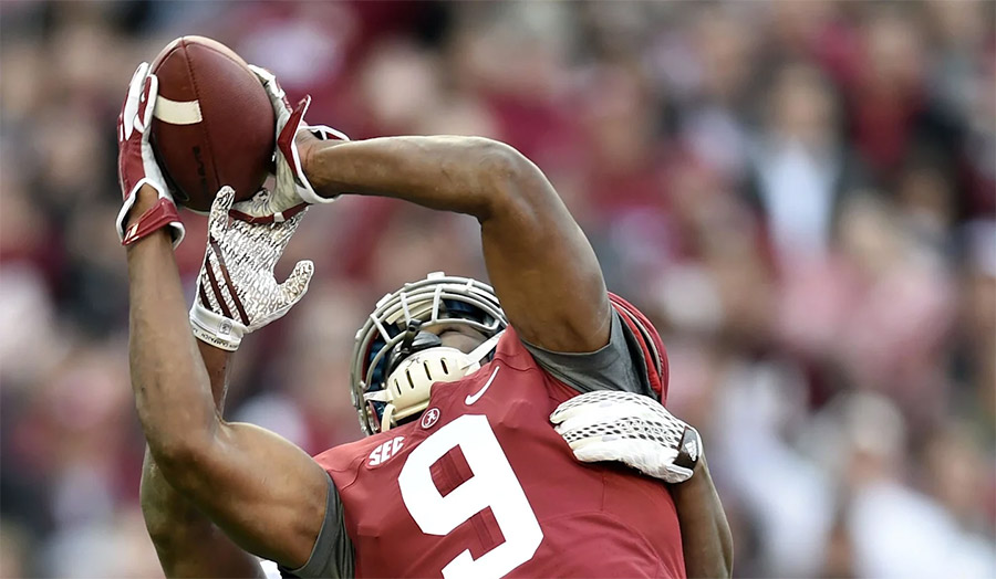 Amari Cooper holding the football after a big play at Alabama