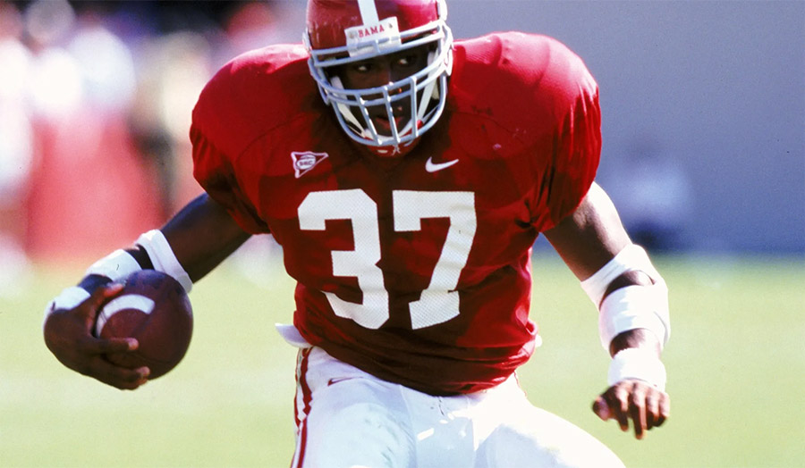 Shaun Alexander running with the ball for Alabama